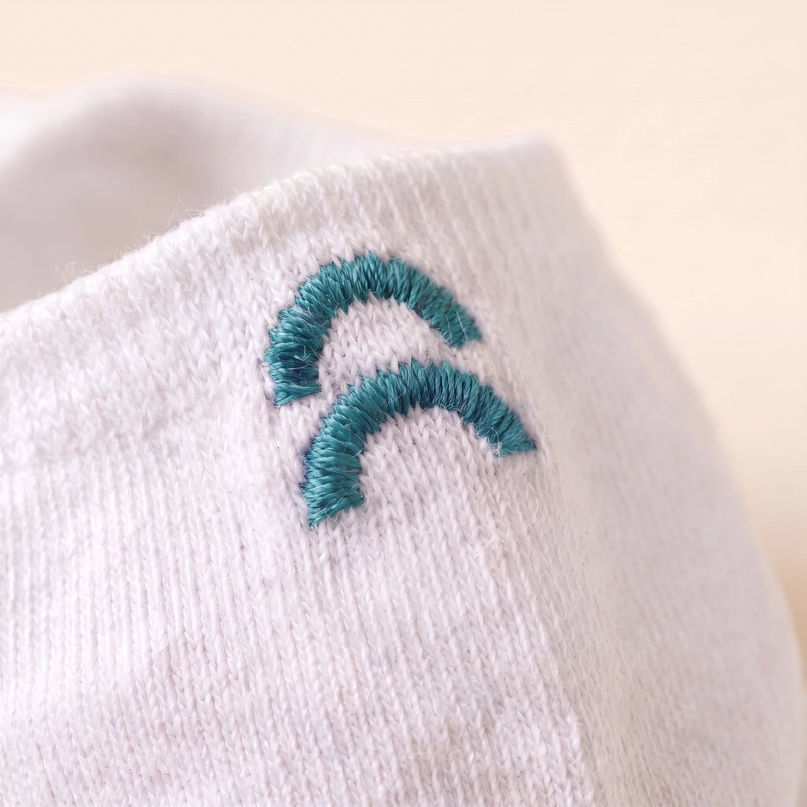 Gestikt kleurlabel Teal op een witte enkelsok
